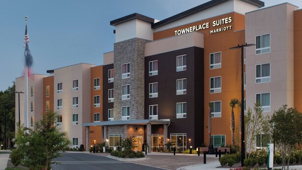 A multi-story hotel with a modern design, featuring a mix of brick and stone facades, and a prominent entrance with a covered area.