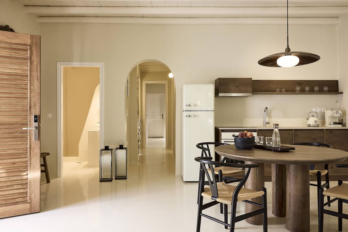 A modern kitchen with a central island, wooden cabinets, and a hanging light fixture.