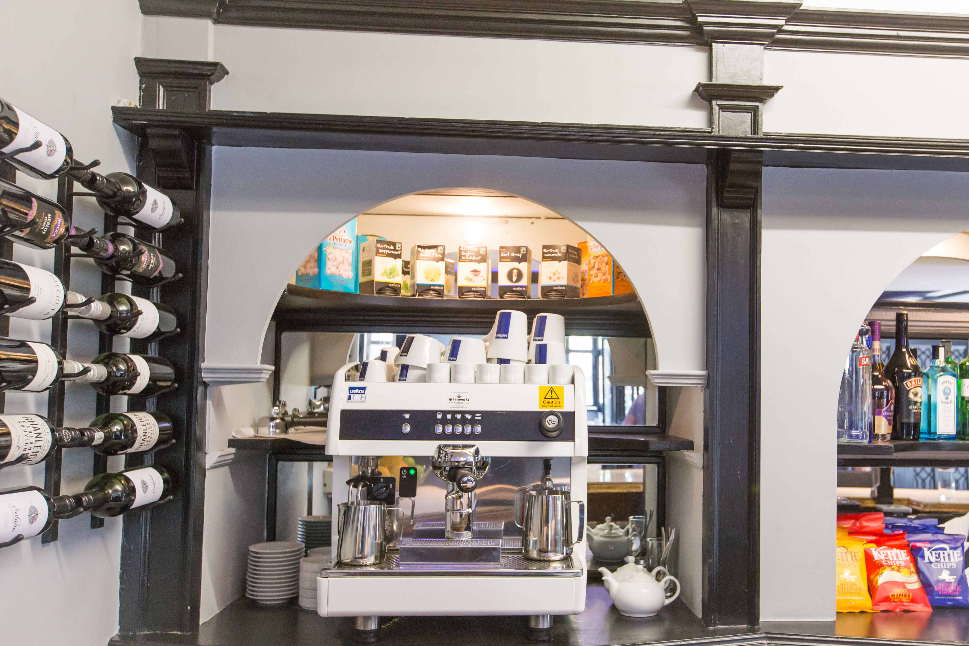 A coffee machine with a display of coffee cups and a selection of coffee pods.