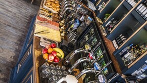 Uma área de bar com um balcão comprido, diversos alimentos e uma seleção de cervejas.