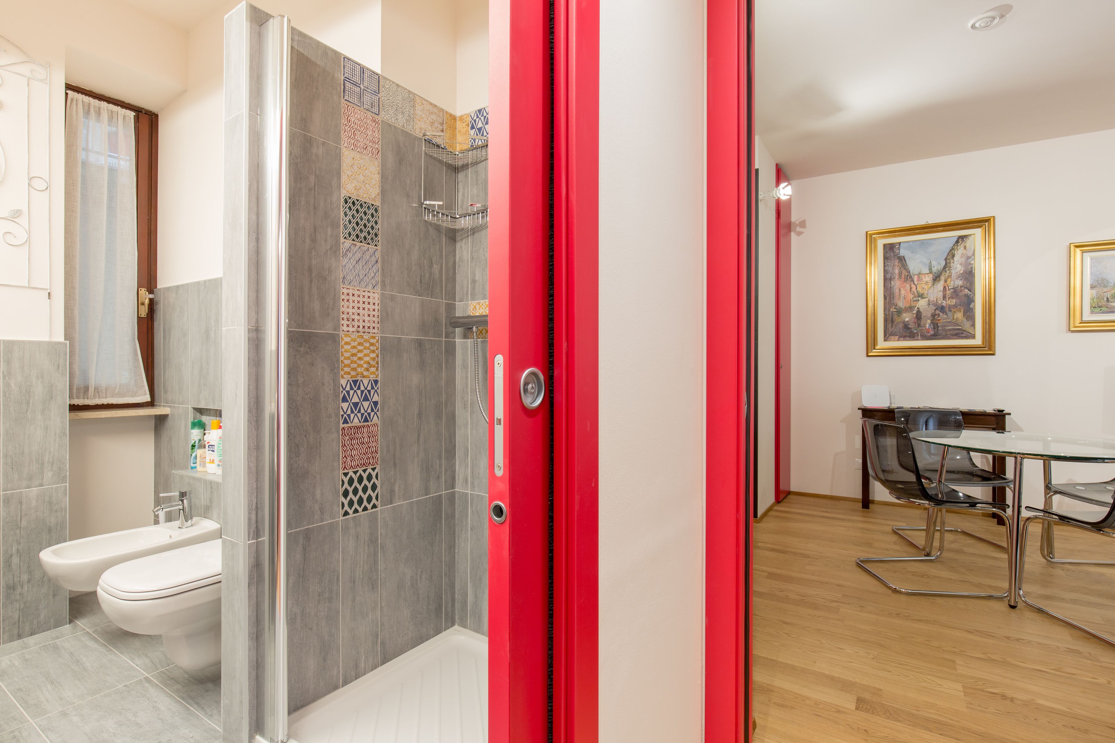 Ein modernes Badezimmer mit Dusche, Toilette und Waschbecken. Es gibt einen Essbereich mit Tisch und Stühlen.
