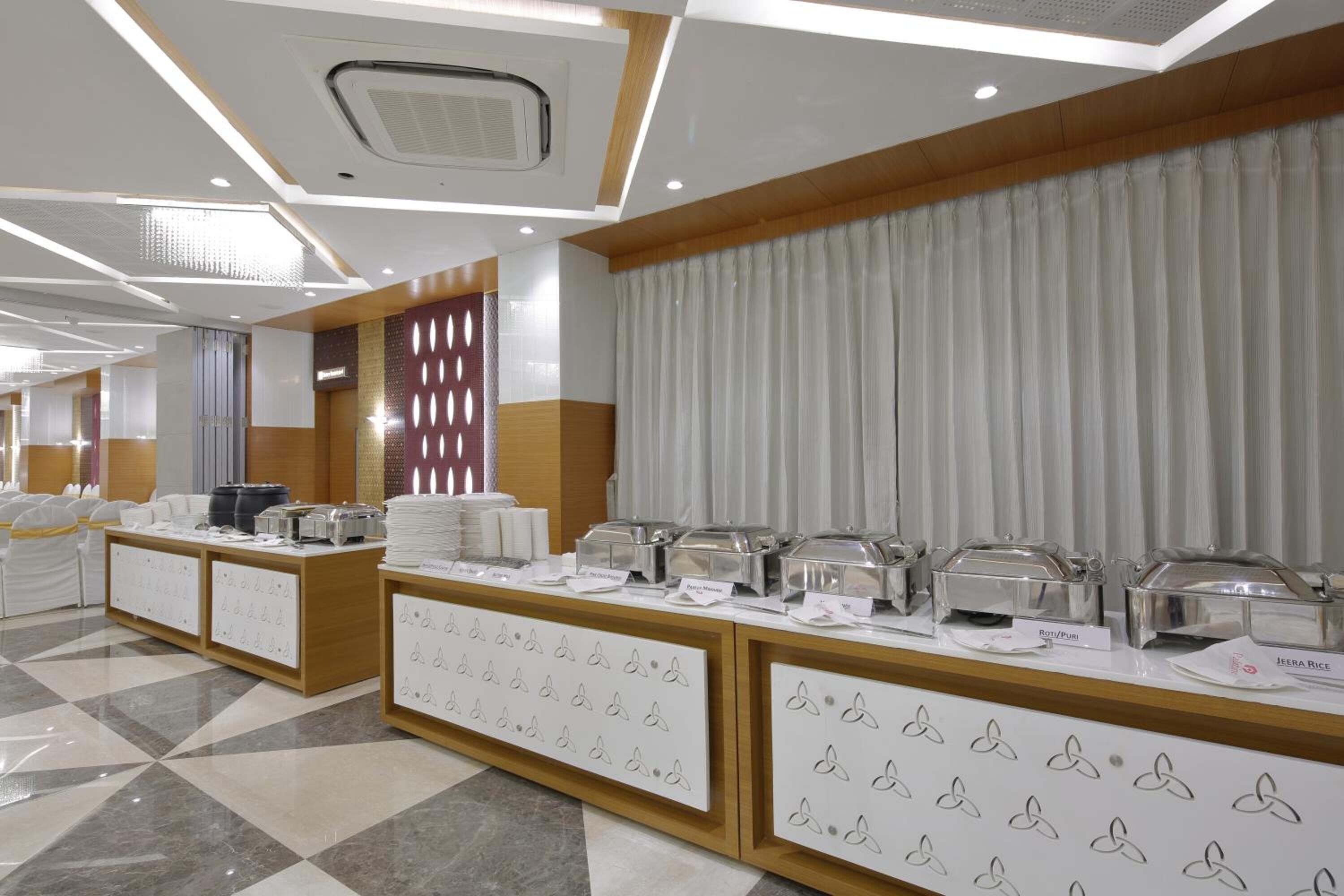 A buffet setup with various food stations and a clear menu display.
