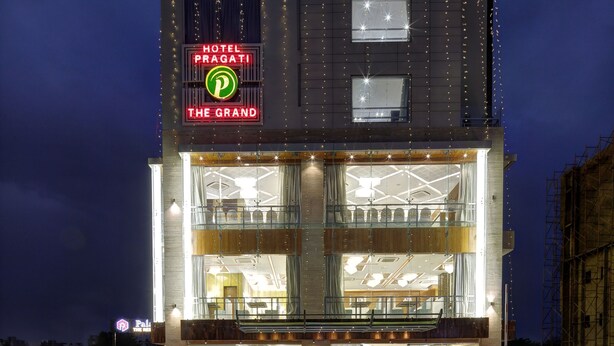 Un hôtel dont l’enseigne, bien visible, porte l’inscription « Hotel Pragati The Grand ».
