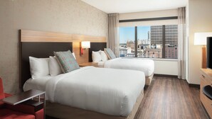 A hotel room with two beds, a desk, a TV, and a city view. - TownePlace Suites New Orleans Downtown/Canal Street (New Orleans)
