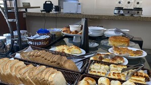 Un bufé con panes y pasteles varios.