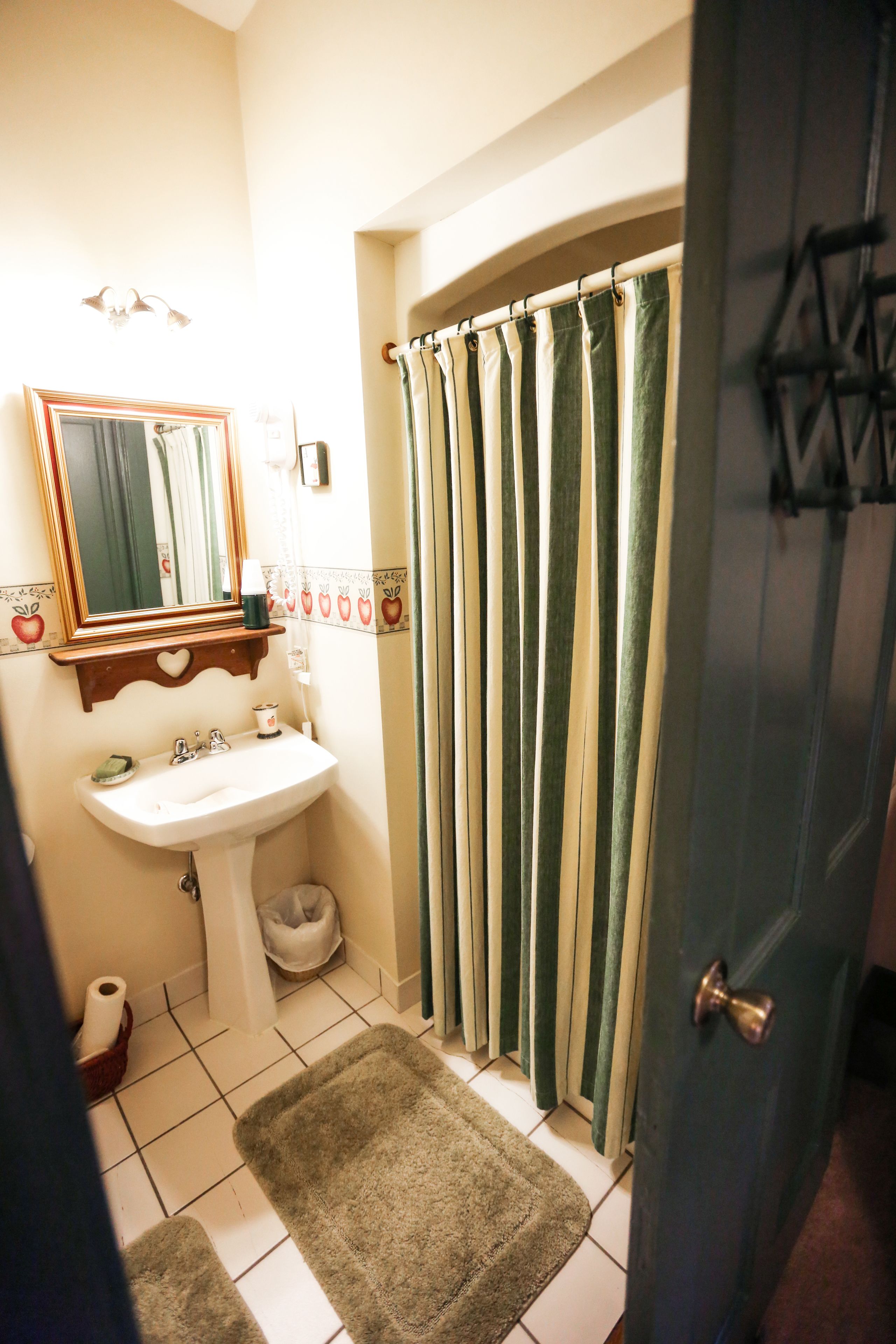 A bathroom with a sink, mirror, and shower curtain.
