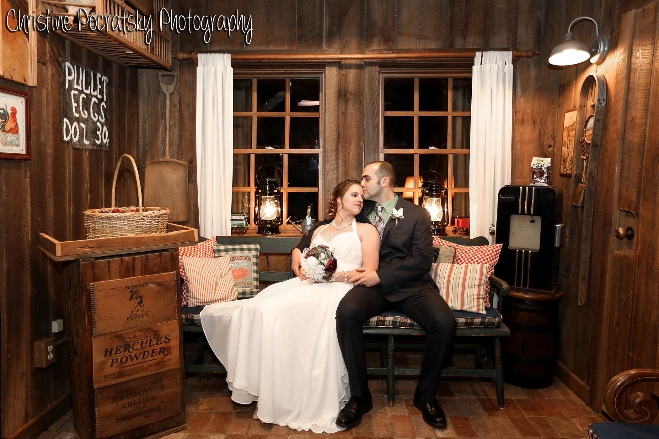 A rustic room with wooden walls, a vintage lamp, a wicker basket, and a sign reading "PULLET EGGS DOZ 30."