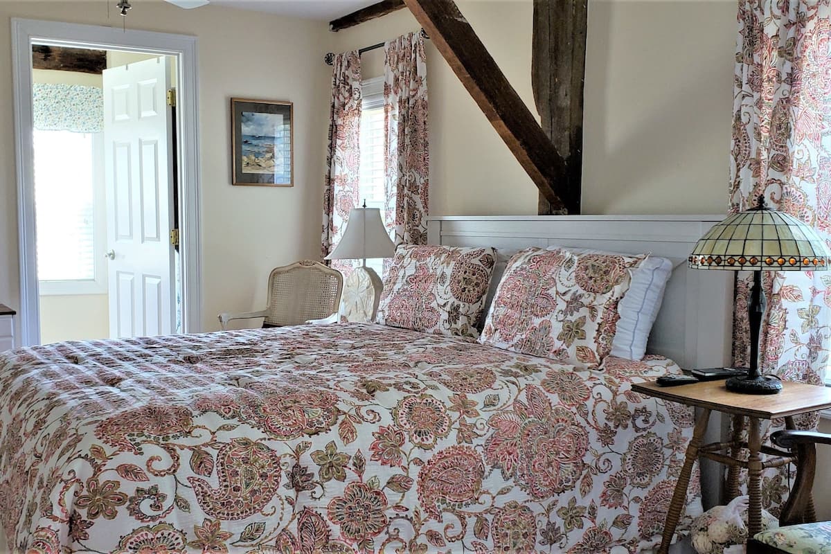 Un dormitorio con cama, cómoda, lámpara y espejo.