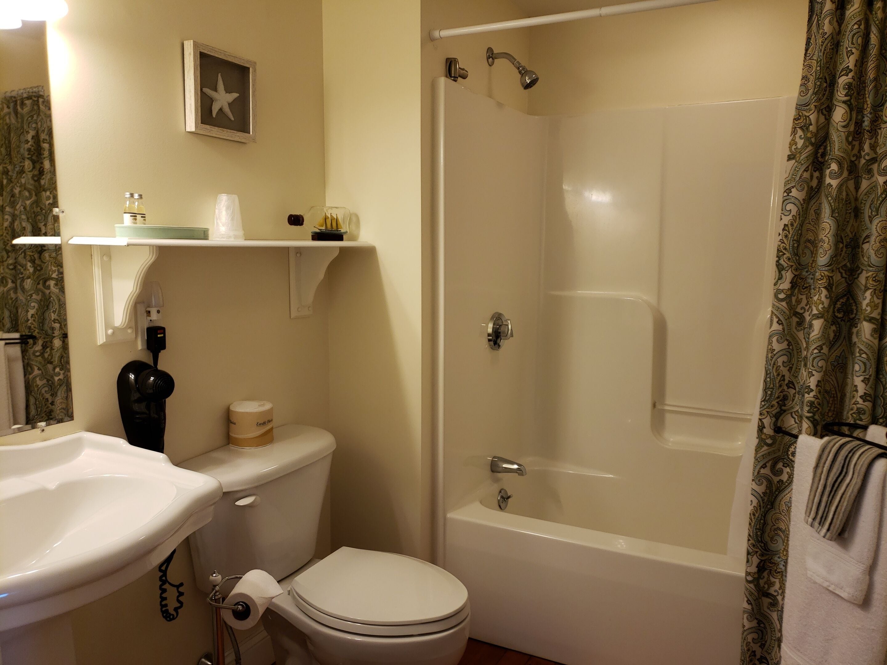 A bathroom with a toilet, sink, and bathtub.