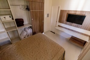 A bedroom with a bed, a TV mounted on the wall, a wardrobe, and a shelf with a microwave. - Lacqua Di Roma - JC Temporada (Caldas Novas)