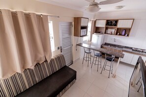 A kitchenette with a microwave, coffee maker, and bar stools. - Lacqua Di Roma - JC Temporada (Caldas Novas)