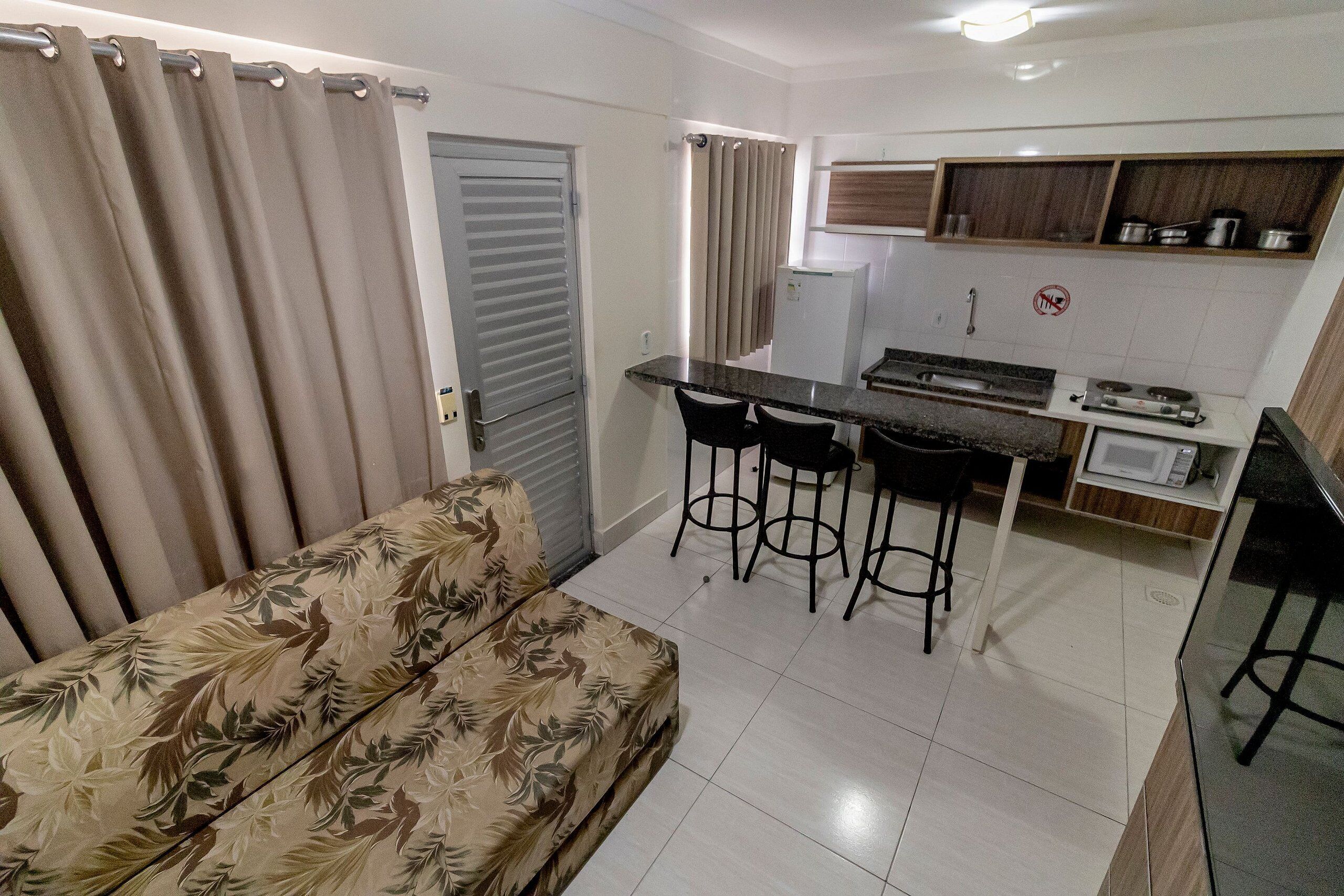 A compact living space with a sofa, a kitchenette, and a dining area.