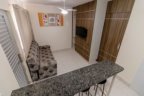 Una cocina moderna con encimera de granito, horno empotrado y un mueble de madera.