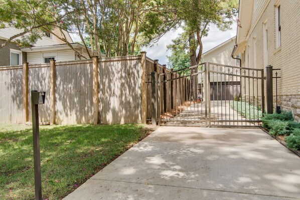 A gated backyard with a concrete pathway leading to a garage. - Caroline House Nashville Historic Inn (Nashville)