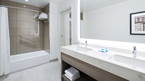 Een bad/douchecombinatie, designer toiletartikelen, een haardroger