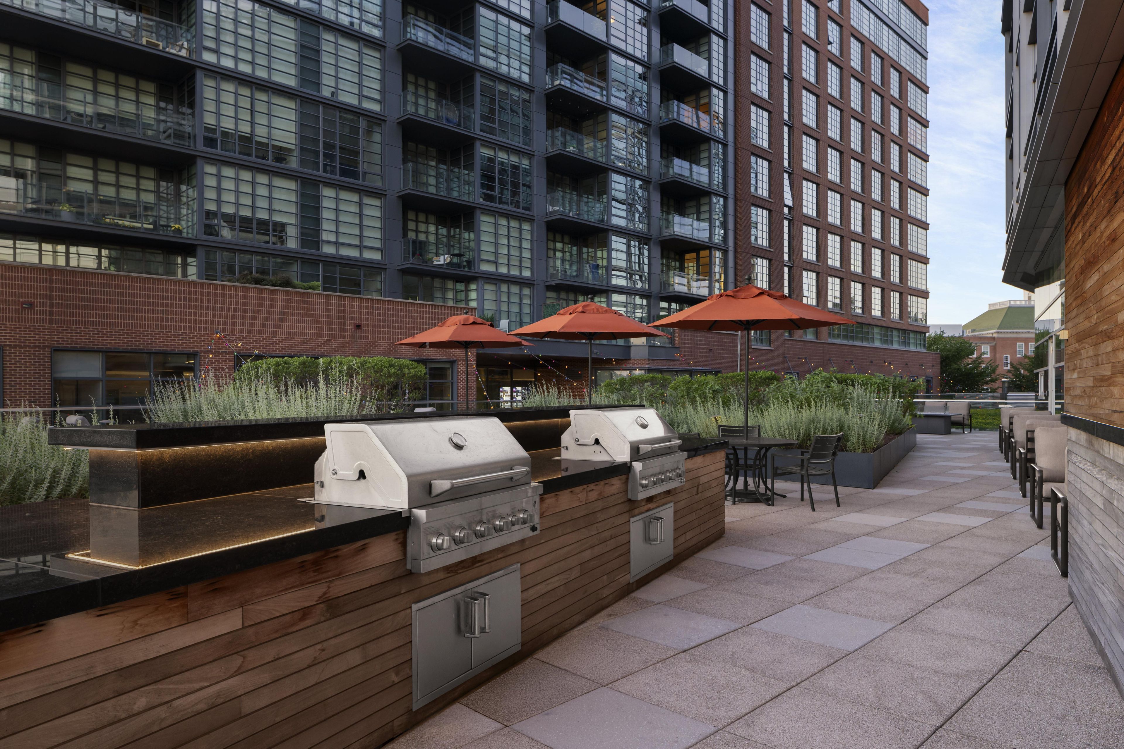 An outdoor patio with a built-in barbecue grill and seating area.