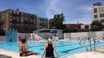 A swimming pool with lane dividers, lounge chairs, and a lifeguard stand.