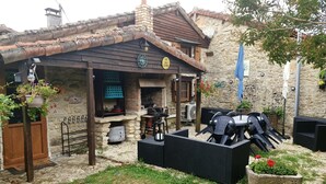 A rustic outdoor dining area with a stone wall, wooden pergola, and a BBQ grill. - Chocolate Box cottage. Relax and let the world go by. (Parzac)
