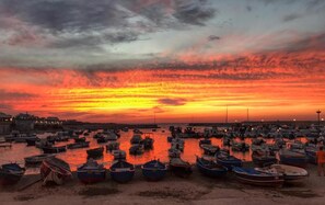 A marina at sunset with numerous boats docked.