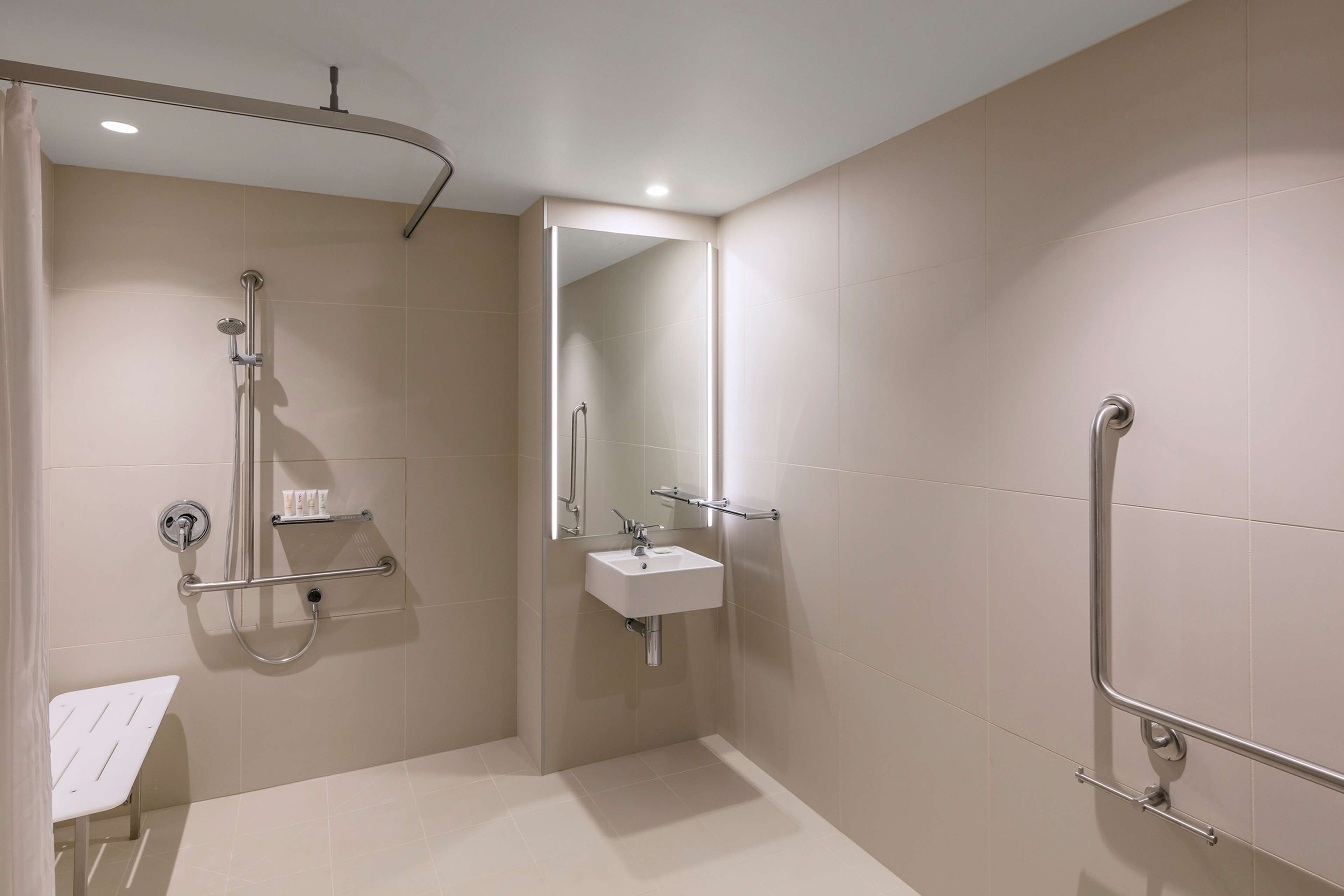 A modern bathroom with a walk-in shower, a sink, and a mirror.