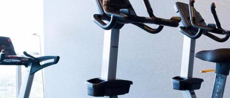 Un gimnasio con bicicletas estáticas y una cinta de correr.