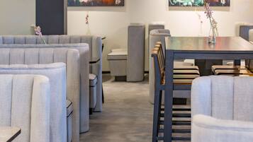 Un restaurante moderno con cabinas tapizadas en gris y una mesa de comedor de madera.