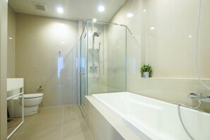 A modern bathroom with a glass-enclosed shower, a white bathtub, and a toilet. - Baan Plai Haad By Pong (Pattaya)
