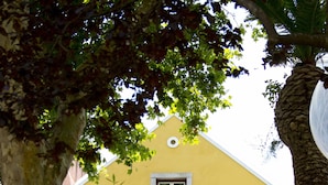 Un bâtiment jaune avec deux fenêtres et un balcon.