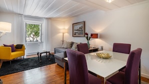 Un salon moderne avec un coin repas, comprenant un canapé, une table et des chaises.