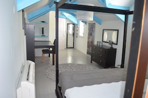 Ein Schlafzimmer mit einem Himmelbett, einem Schreibtisch und einer Kommode.