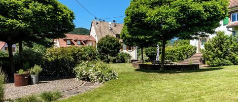 A residential area with houses, a paved path, and a grassy lawn.