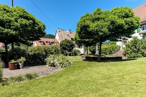 A residential area with houses, a paved path, and a grassy lawn. - Apartment Garden and Mountain View (Breitenbach-Haut-Rhin)