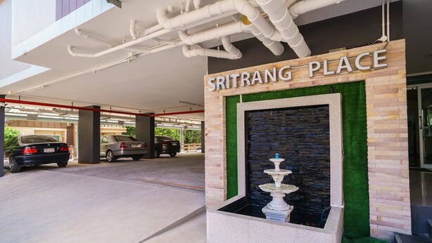 A parking area with a sign reading "Sritrang Place" and a decorative fountain. - Sritrang Place (Hat Yai)