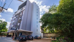 A multi-story building with a white facade, a covered entrance, and a sign indicating a USIS room. - Sritrang Place (Hat Yai)