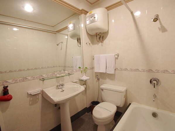 A bathroom with a sink, toilet, bathtub, and a water heater.