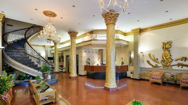 A grand lobby with a spiral staircase, a reception desk, and ornate columns. - The Spring Hotel (Ho Chi Minh City)