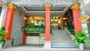 The exterior of SPRING HOTEL with a grand entrance, red columns, and a staircase leading to the entrance. - The Spring Hotel (Ho Chi Minh City)