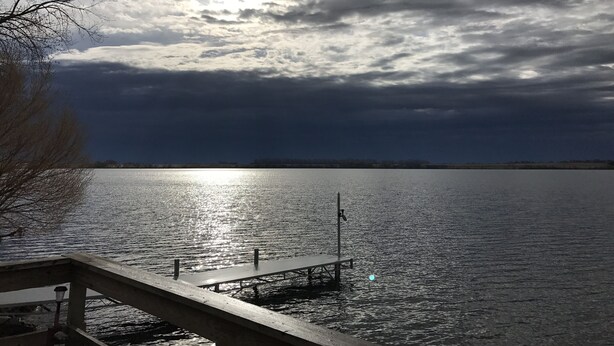Un lago tranquilo con un muelle que se adentra en el agua.