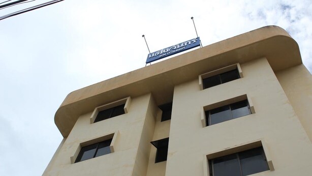 Un edificio de varios pisos con fachada plana, varias ventanas y un letrero en la parte superior.