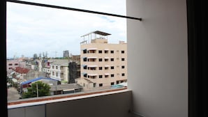 Un edificio alto con varios balcones y vistas de edificaciones circundantes.