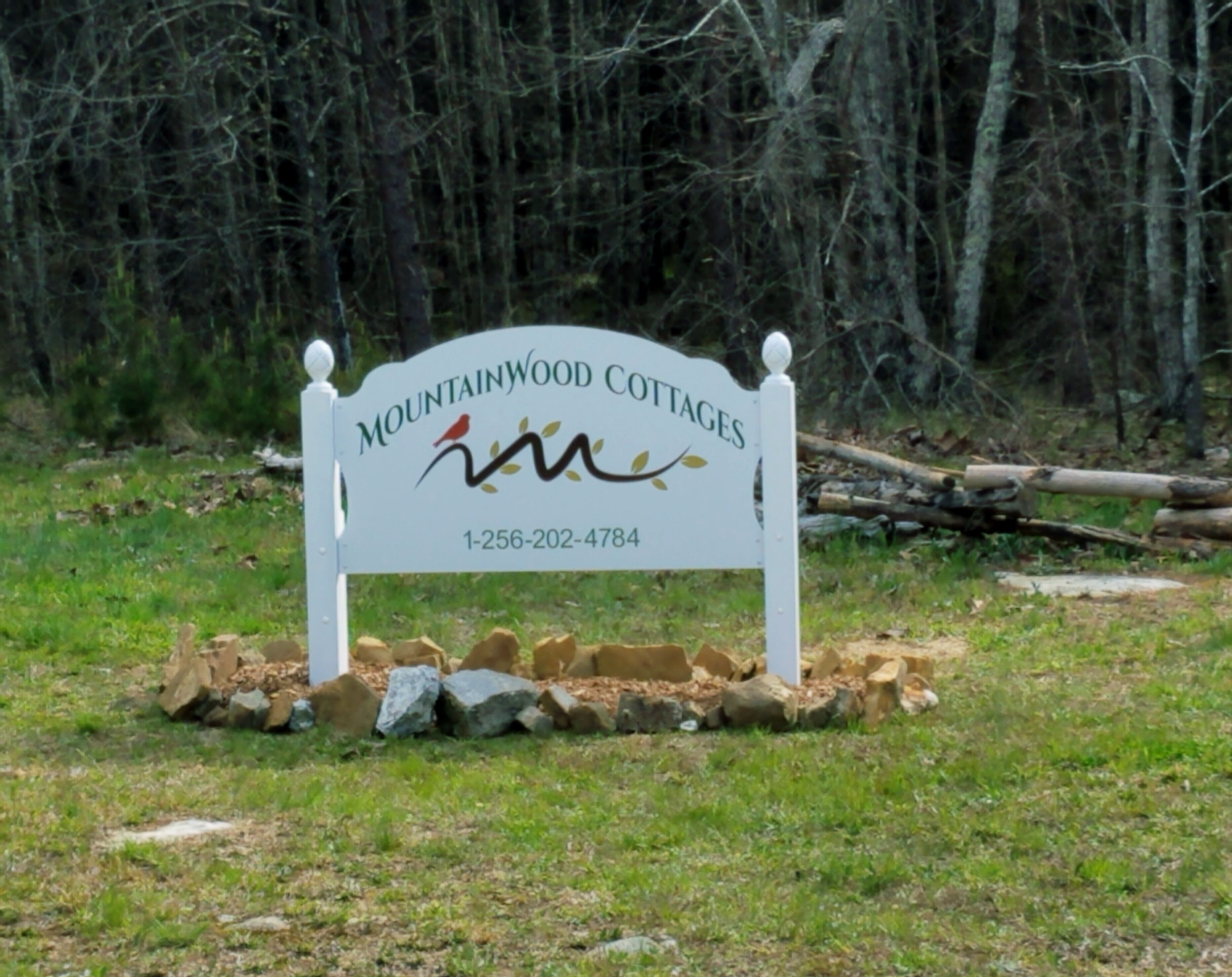 A sign for Mountainwood Cottages with a contact number.