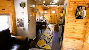 Un intérieur de camping-car compact comprenant un espace de vie, un coin cuisine et un petit espace repas.