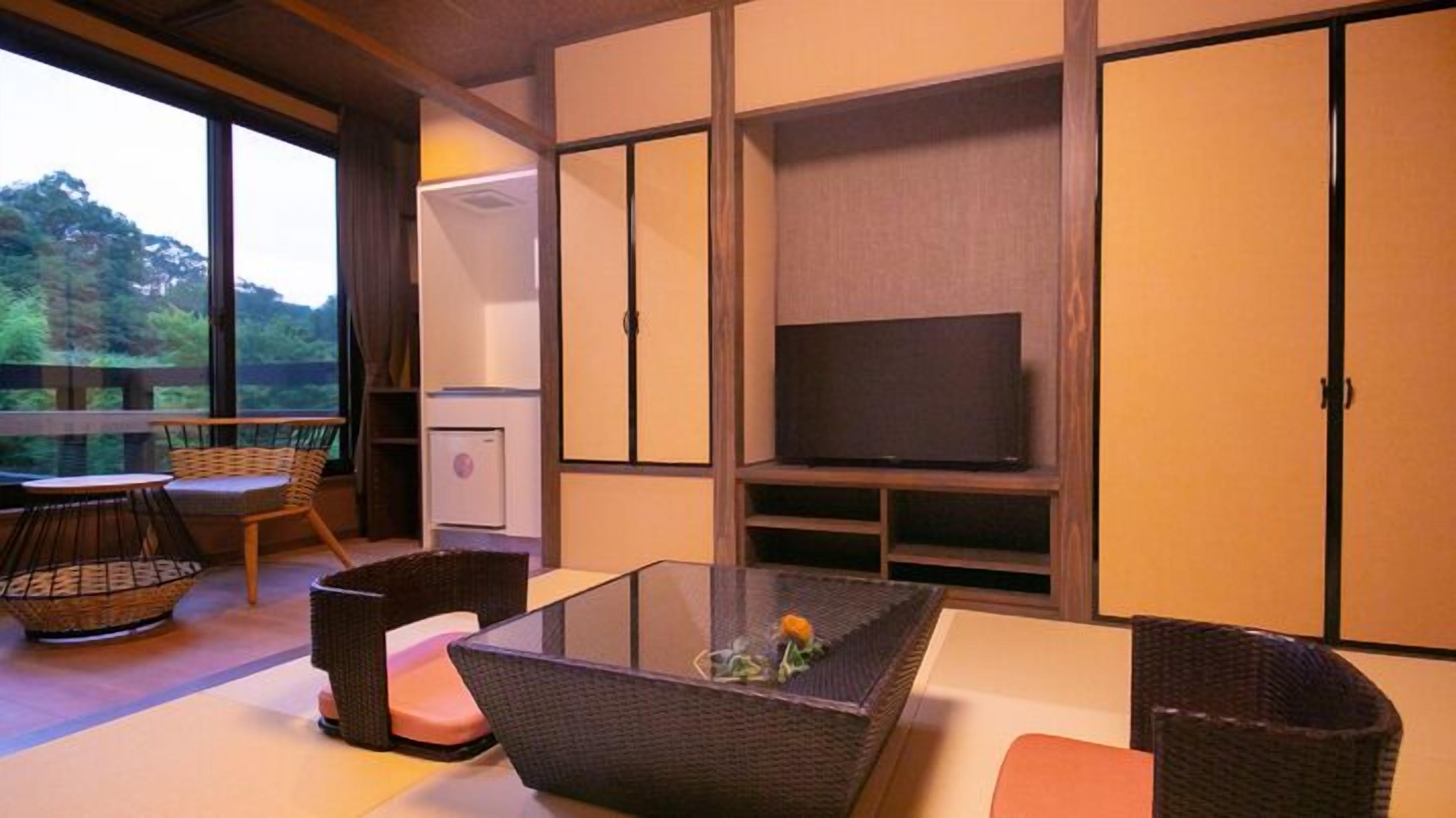 A room with a glass table, wicker furniture, a television, and sliding doors.
