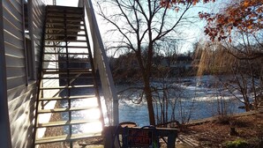 A private property sign near a river, with a wooden staircase leading to a house. - River View. Rent Historic Mill's 2nd Floor. Rustic Timber-frame Construction (Shell Rock)