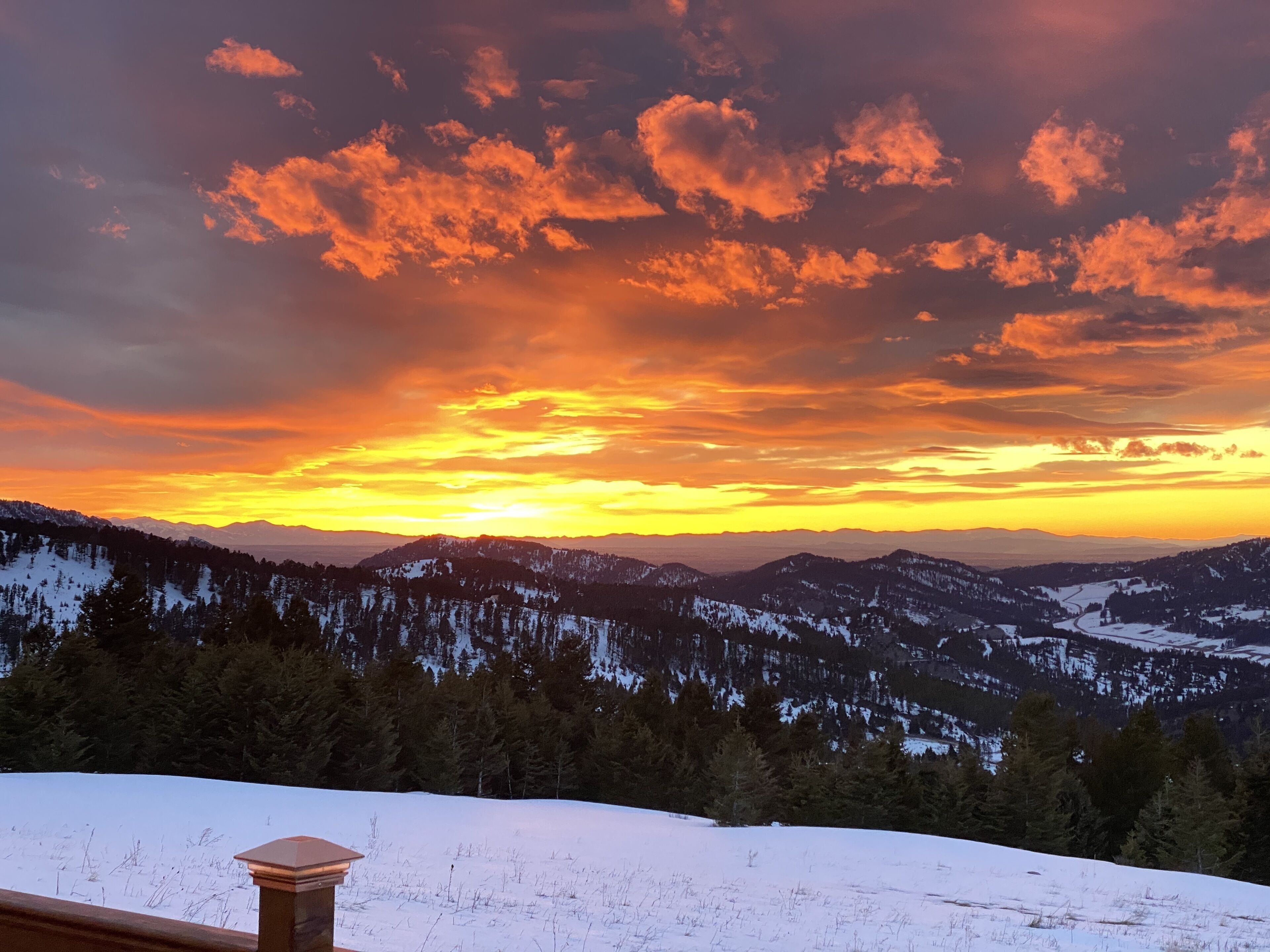 A panoramic view of a mountainous landscape with a sunset.