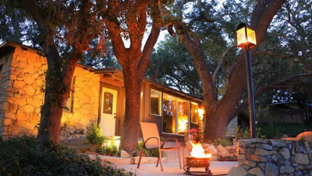 A stone house with a fire pit and outdoor seating.