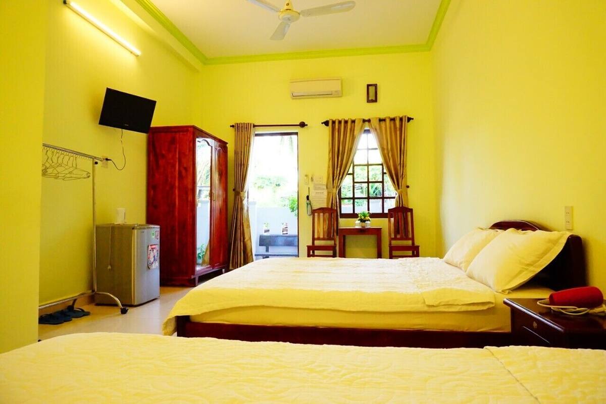 A hotel room with a large bed, a desk, a chair, and a television.