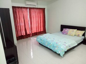 A bedroom with a bed, a window with red curtains, and a white air conditioning unit on the wall. - SK Homestay 2 (Lumut)