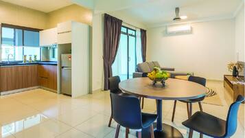 A modern kitchen with wooden cabinets, a built-in fridge, and a dining area with a round table and chairs.