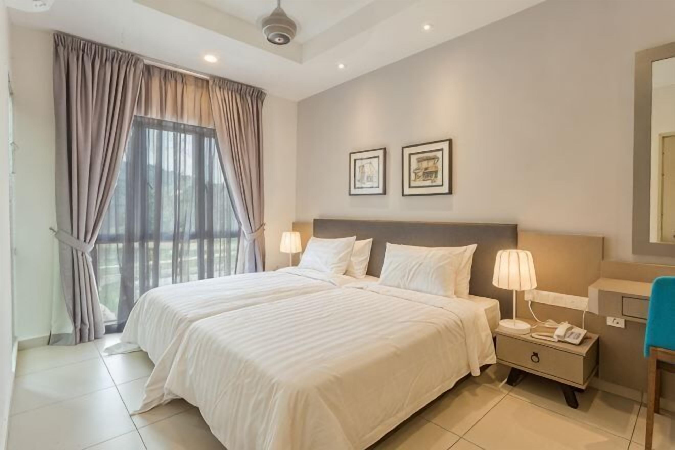 A double bed with a nightstand, a lamp, and a phone.